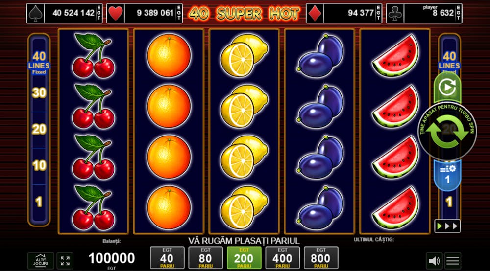 Pe ecran se vede o captură de ecran a jocului slot online 40 Super Hot. Slotul are fundal roșu și simboluri cu fructe clasice: pepeni, struguri, prune, lămâi, portocale și cireșe. Jocul are 40 linii de plată și jackpot progresiv.